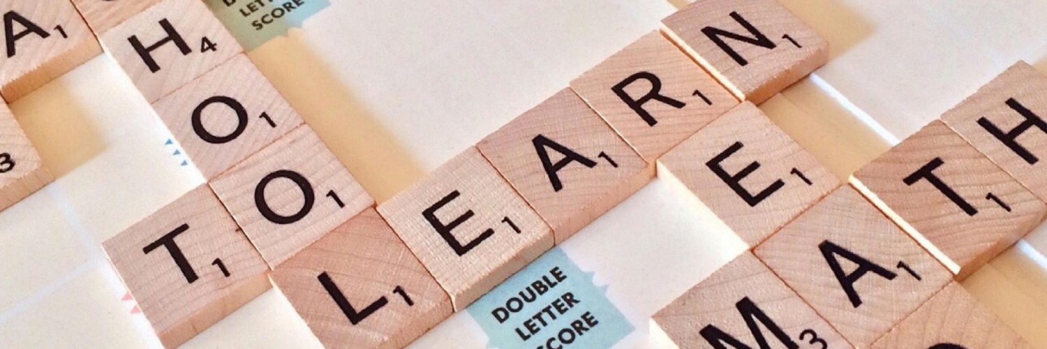 Close-up of Scrabble tiles forming words related to education and school.